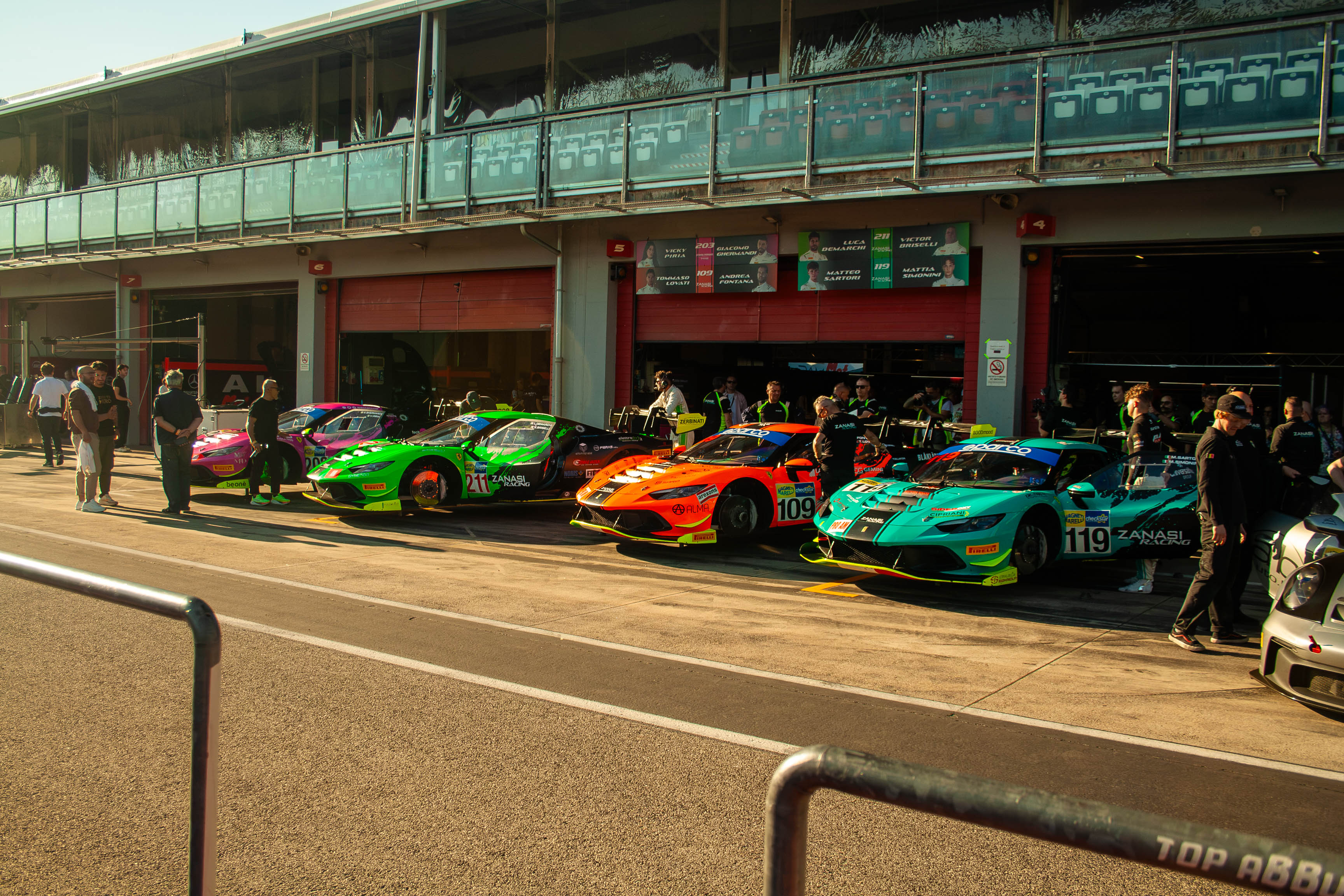 Row of Ferrari 296 Challenge race cars parked in the pit lane at Imola Circuit