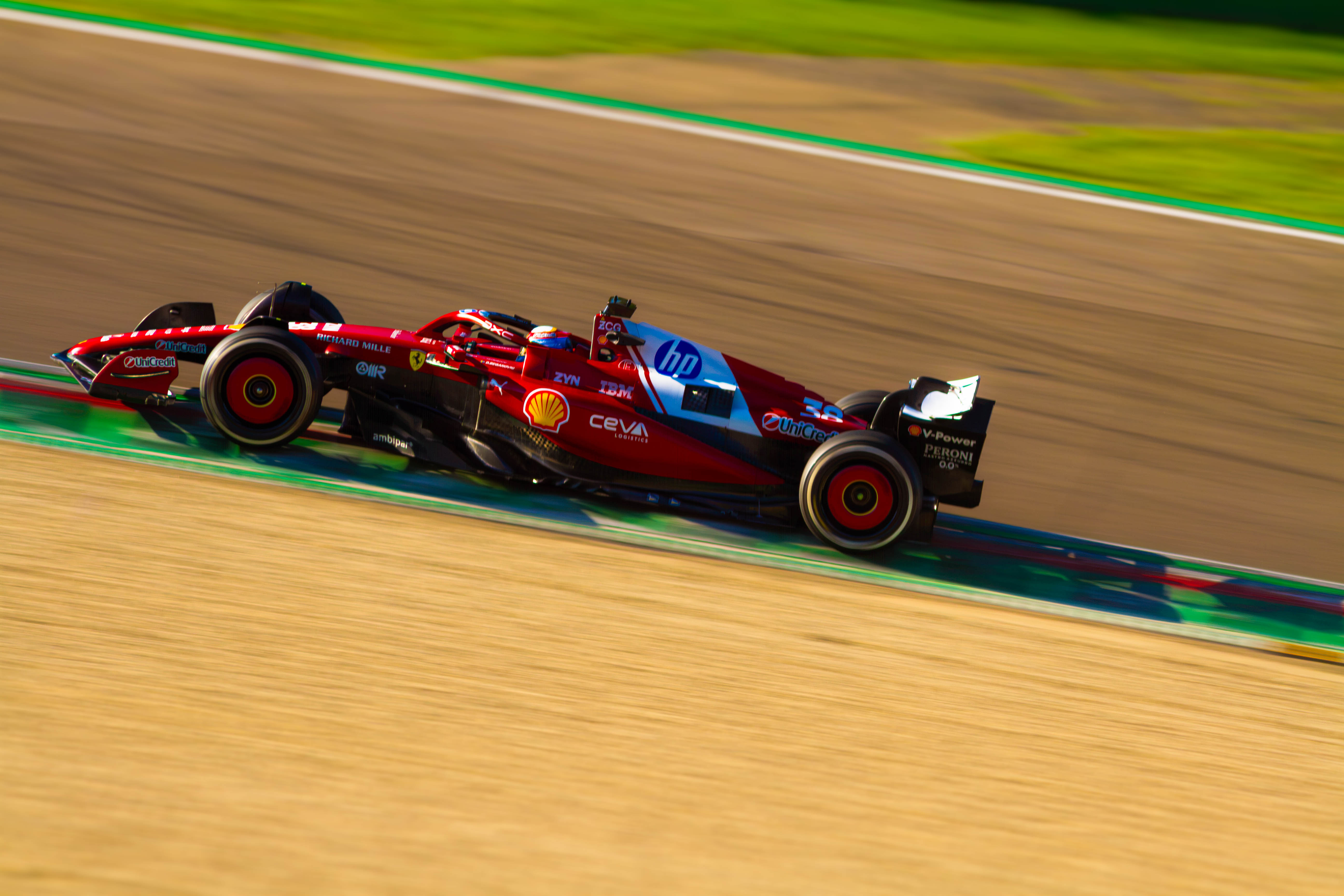 Vista laterale con panning della Scuderia Ferrari SF-24 di Formula 1 in piega sulla corda all'Autodromo di Imola